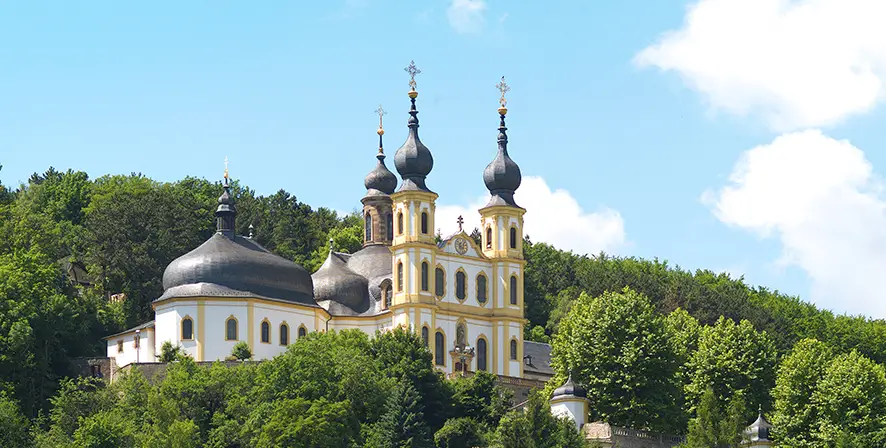 Wahlfahrtskirche Käppele umgeben von Wald über der Stadt Würzburg