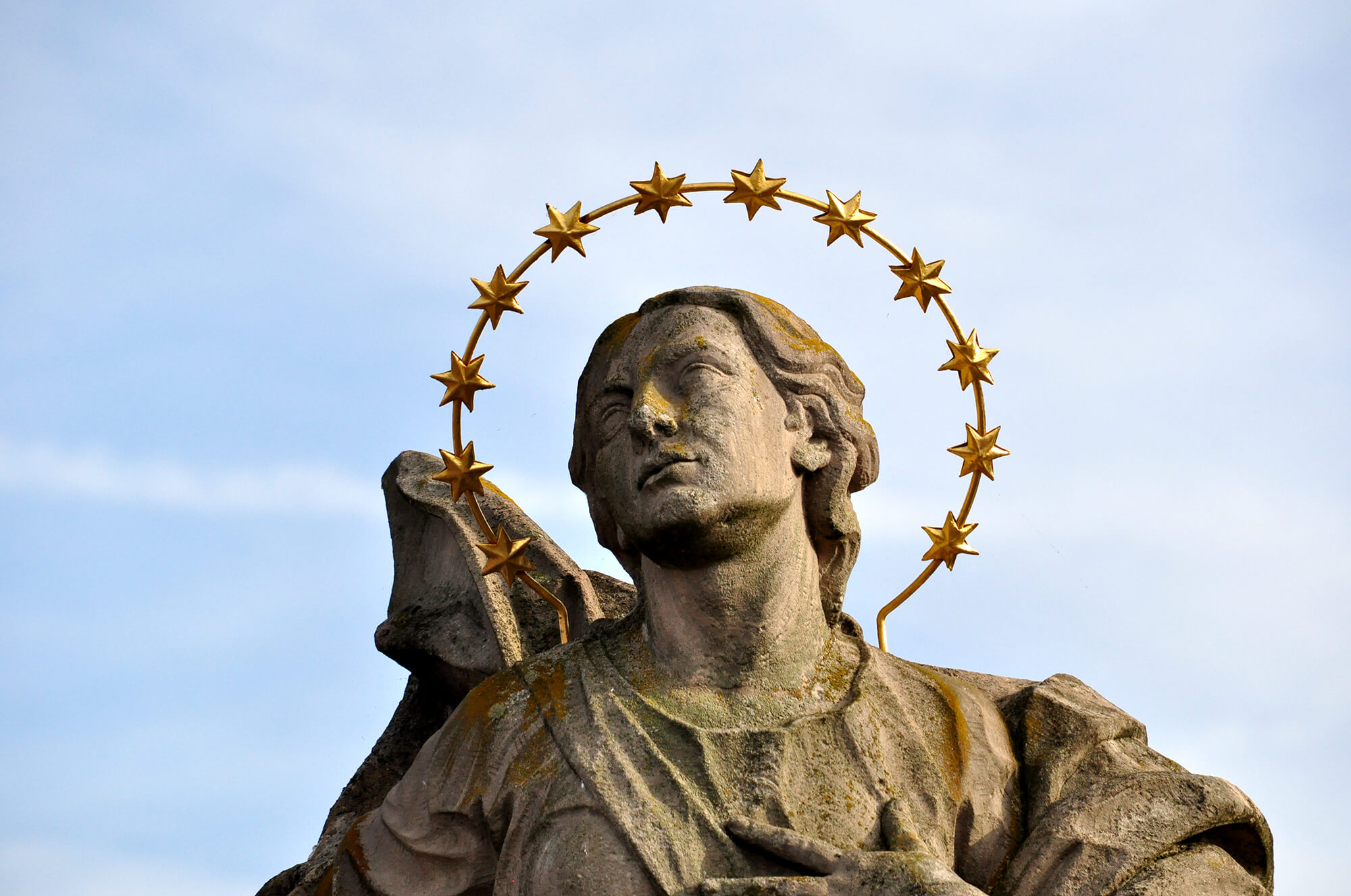 Sandsteinfigur mit goldenem Heiligenschein auf der Alten Mainbrücke in Würzburg